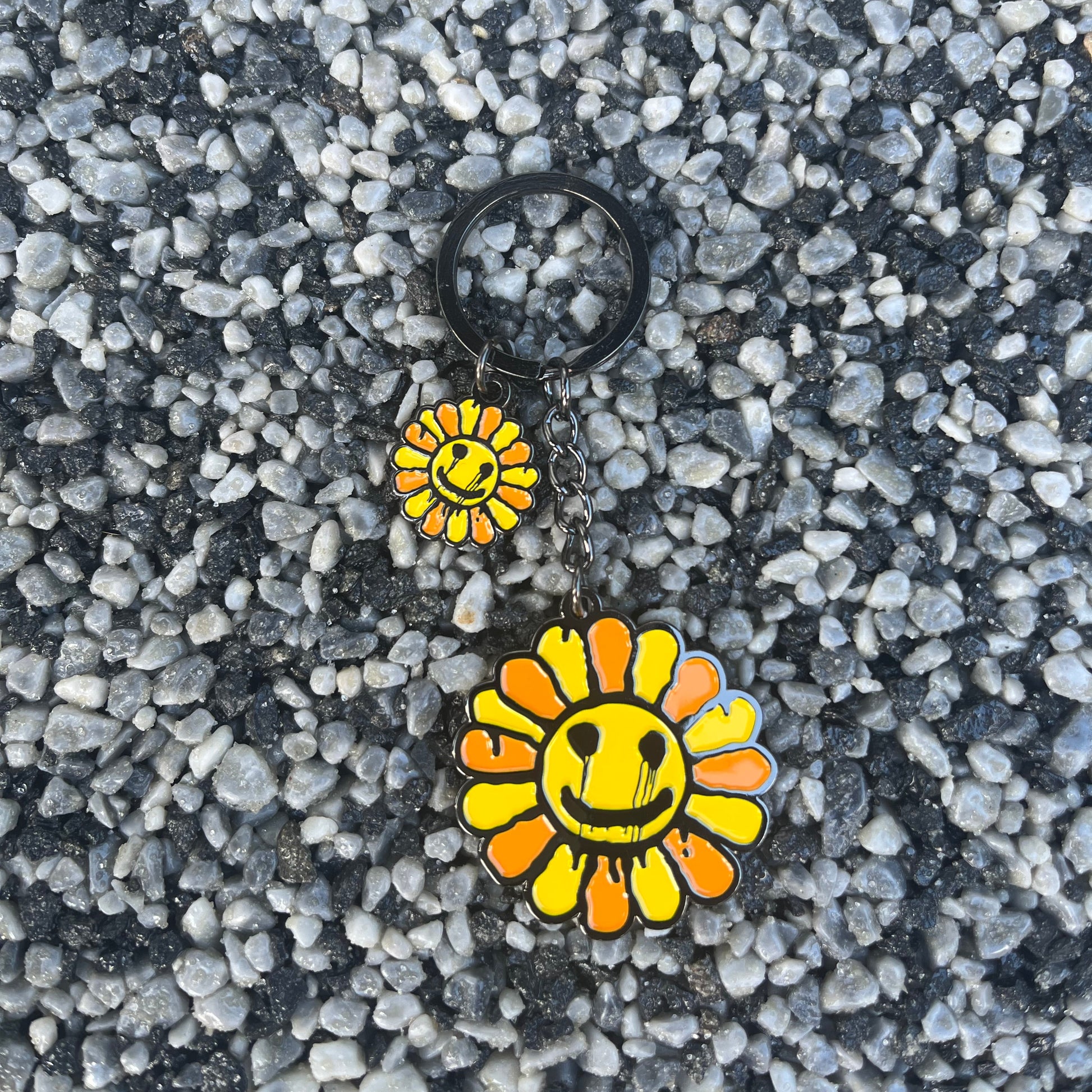 Two sunflower-shaped pins on a textured gray surface