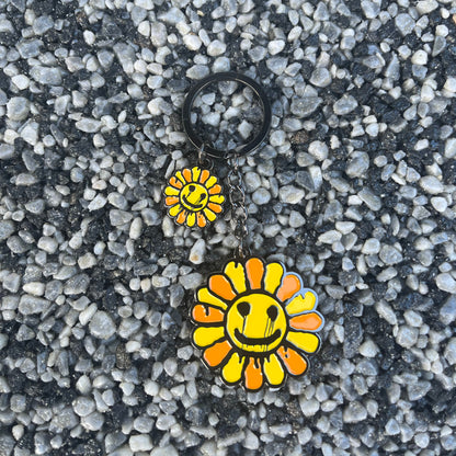 Two sunflower-shaped pins on a textured gray surface