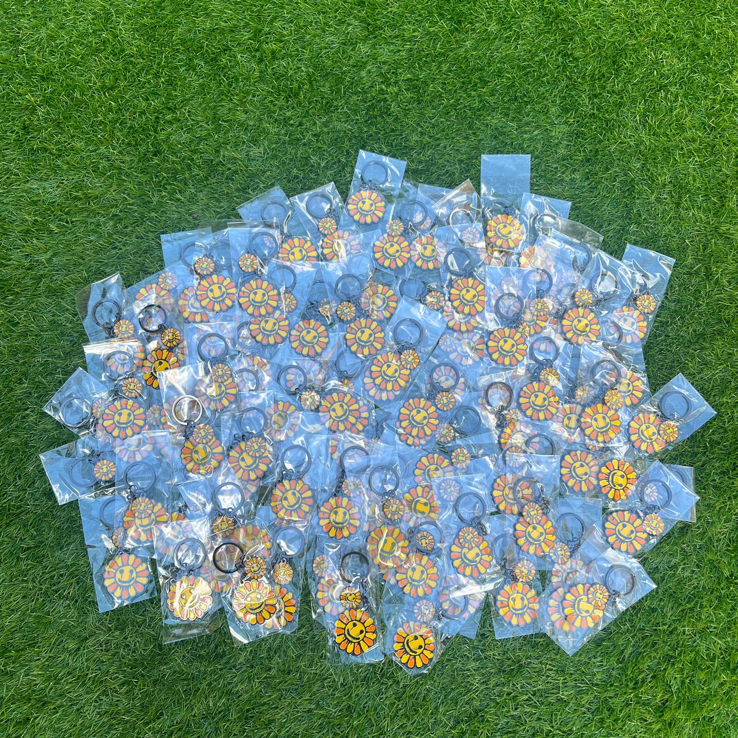 Stack of clear plastic bags with floral designs on a green grass background