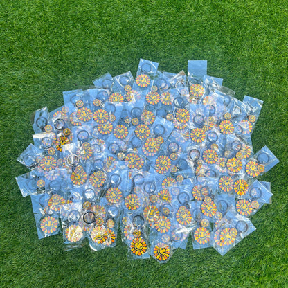 Stack of clear plastic bags with floral designs on a green grass background